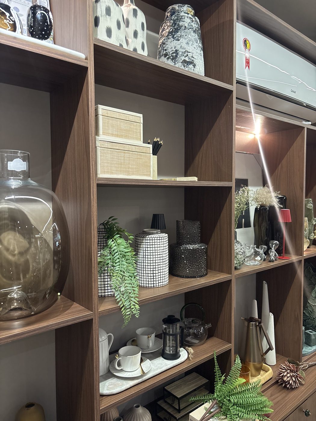 Estante da loja com vasos, cestos e luminárias